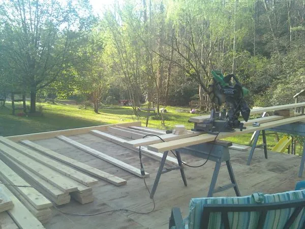 Miter saw and framing lumber on a deck under construction in Corinth